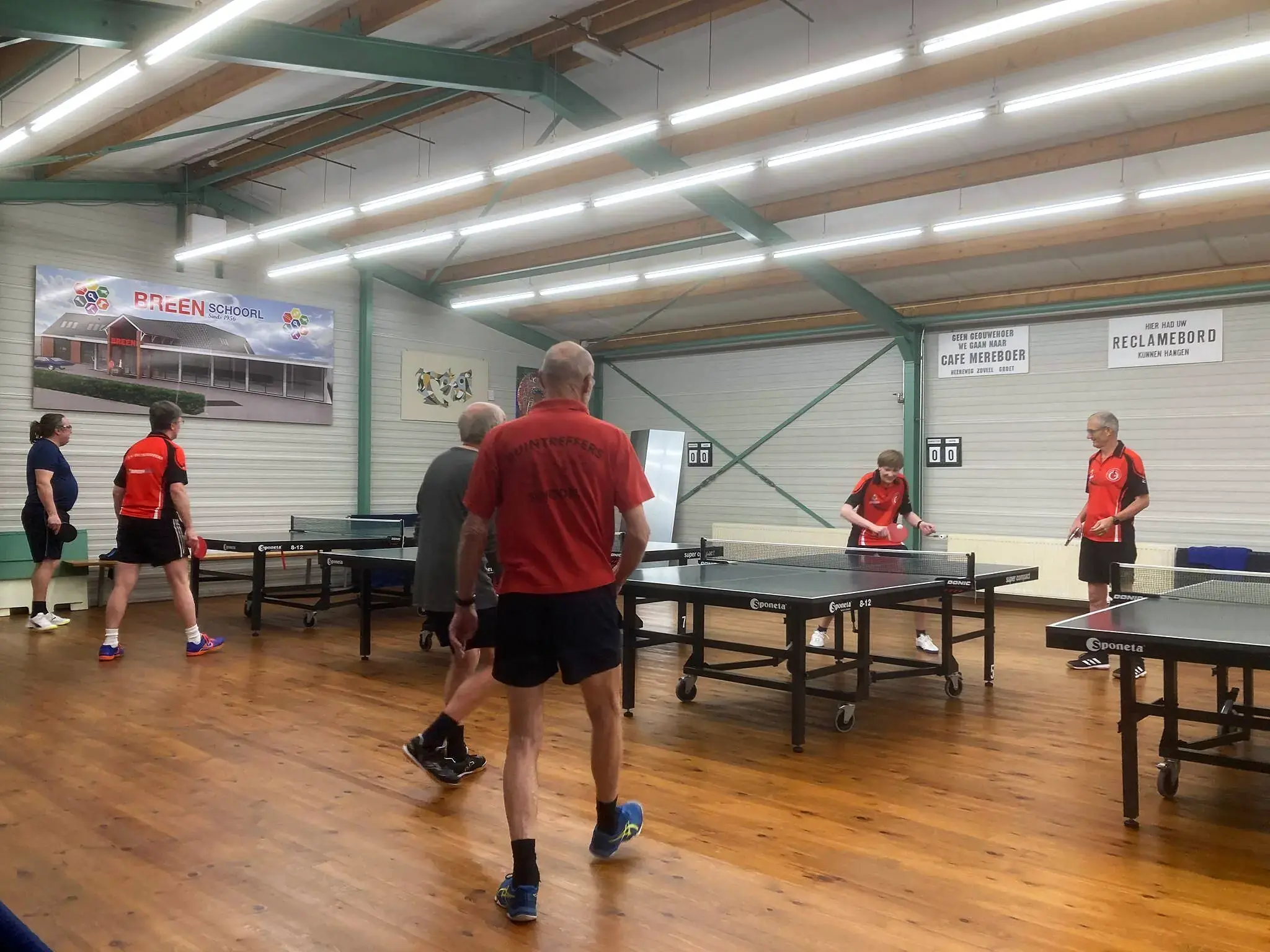Leden spelen tafeltennis in de zaal van Duintreffers
